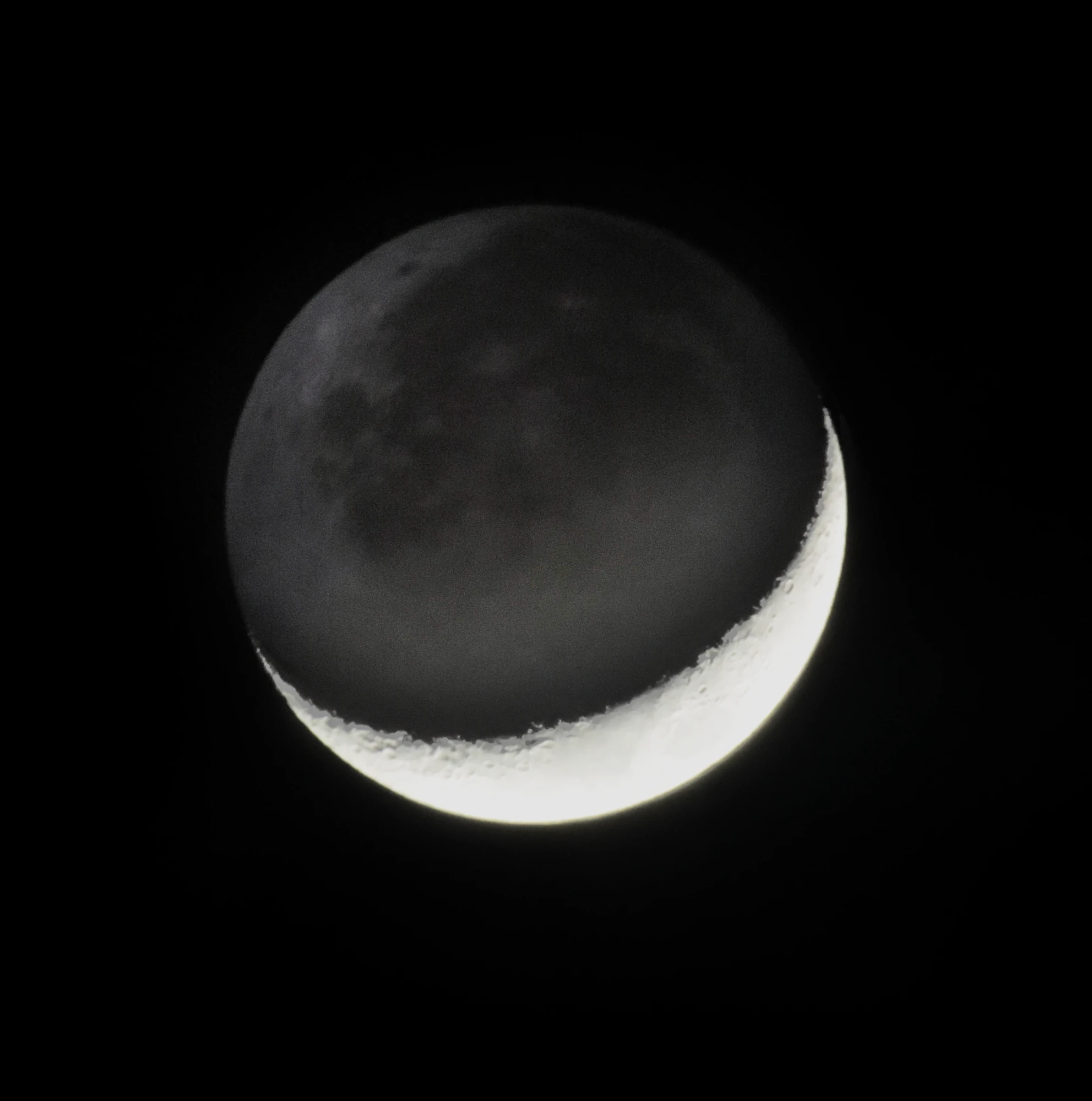 A crescent Moon, the unlit rest of its disc faintly visible against black