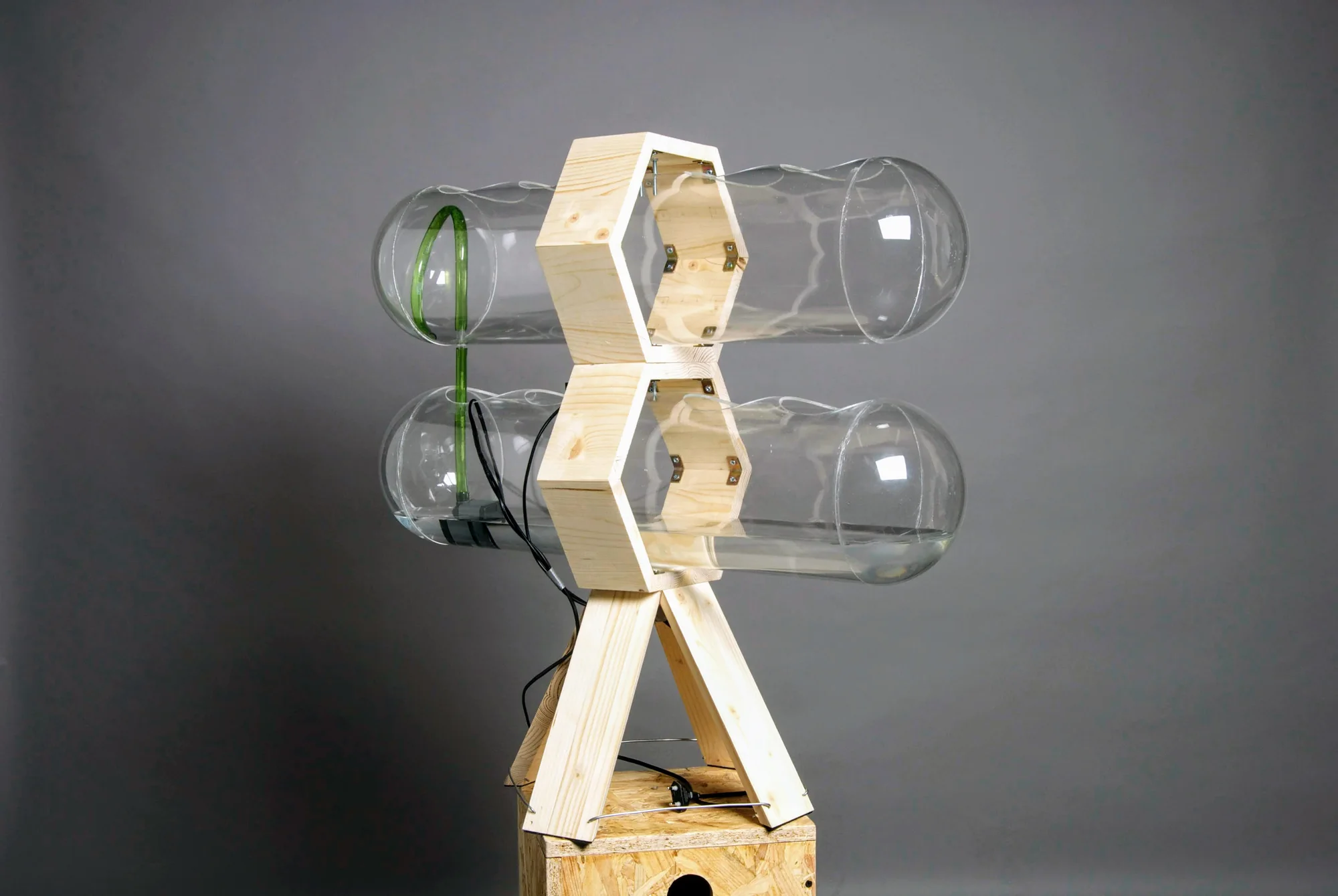Photograph of the ACCUA prototype: two clear bottles held in a plywood frame