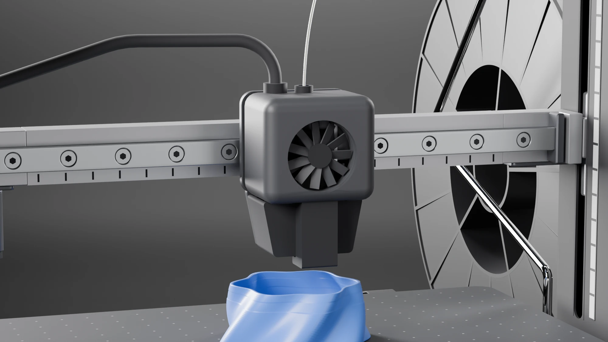 Close-up of the toolhead: a graphite shell with a round fan opening in which the blades show, on a plate that hangs from a block on a profile rail with sunk screw heads, and a printed scale under the rail